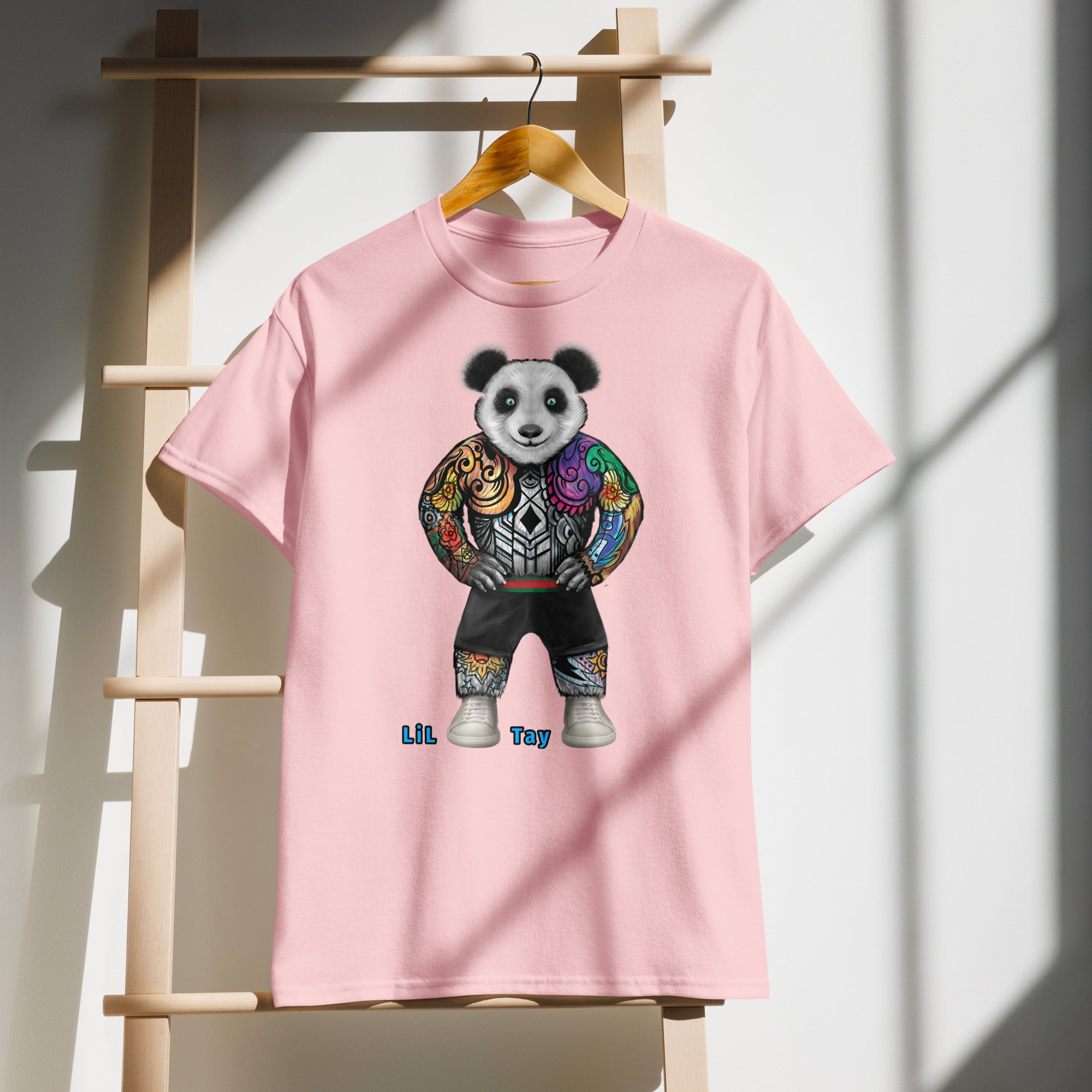Pink t-shirt with a panda design on a wooden hanger against a white wall.