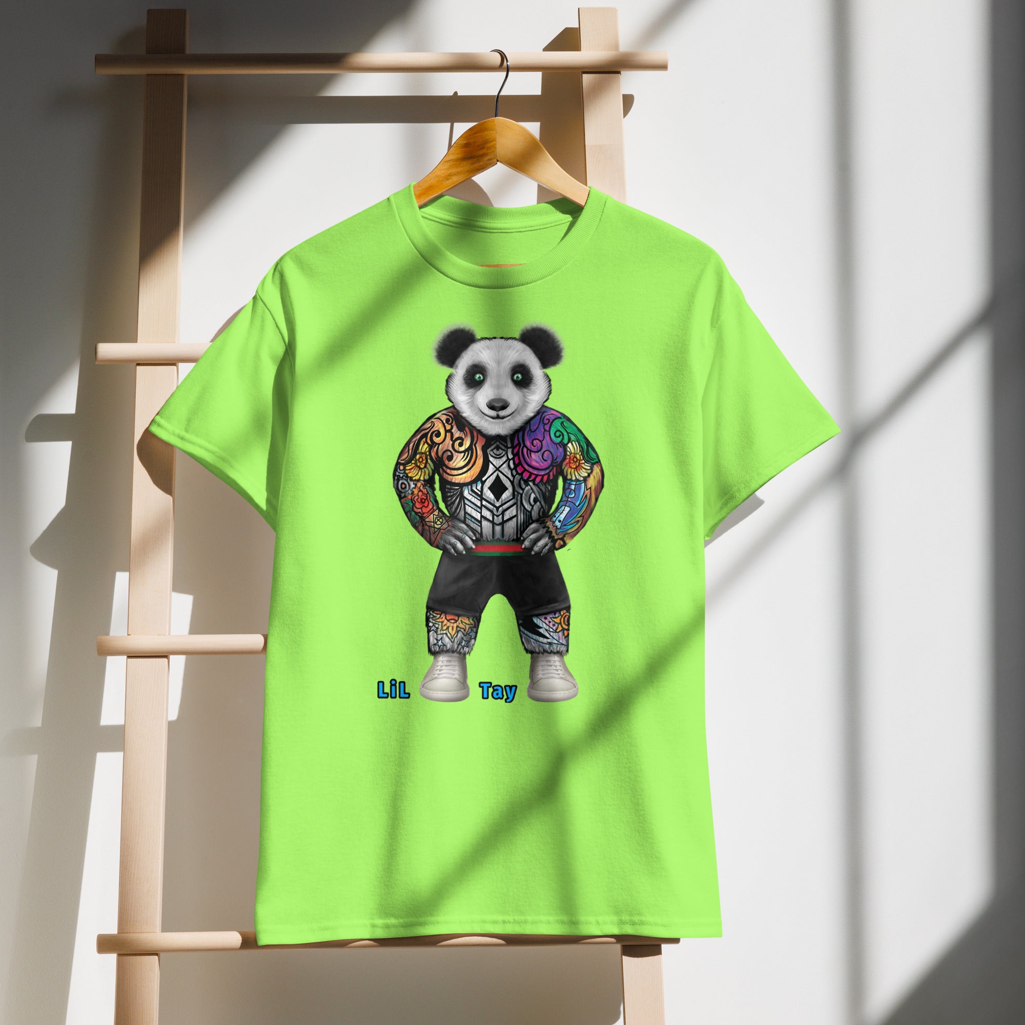 Green t-shirt with a colorful panda design on a wooden hanger against a white wall.