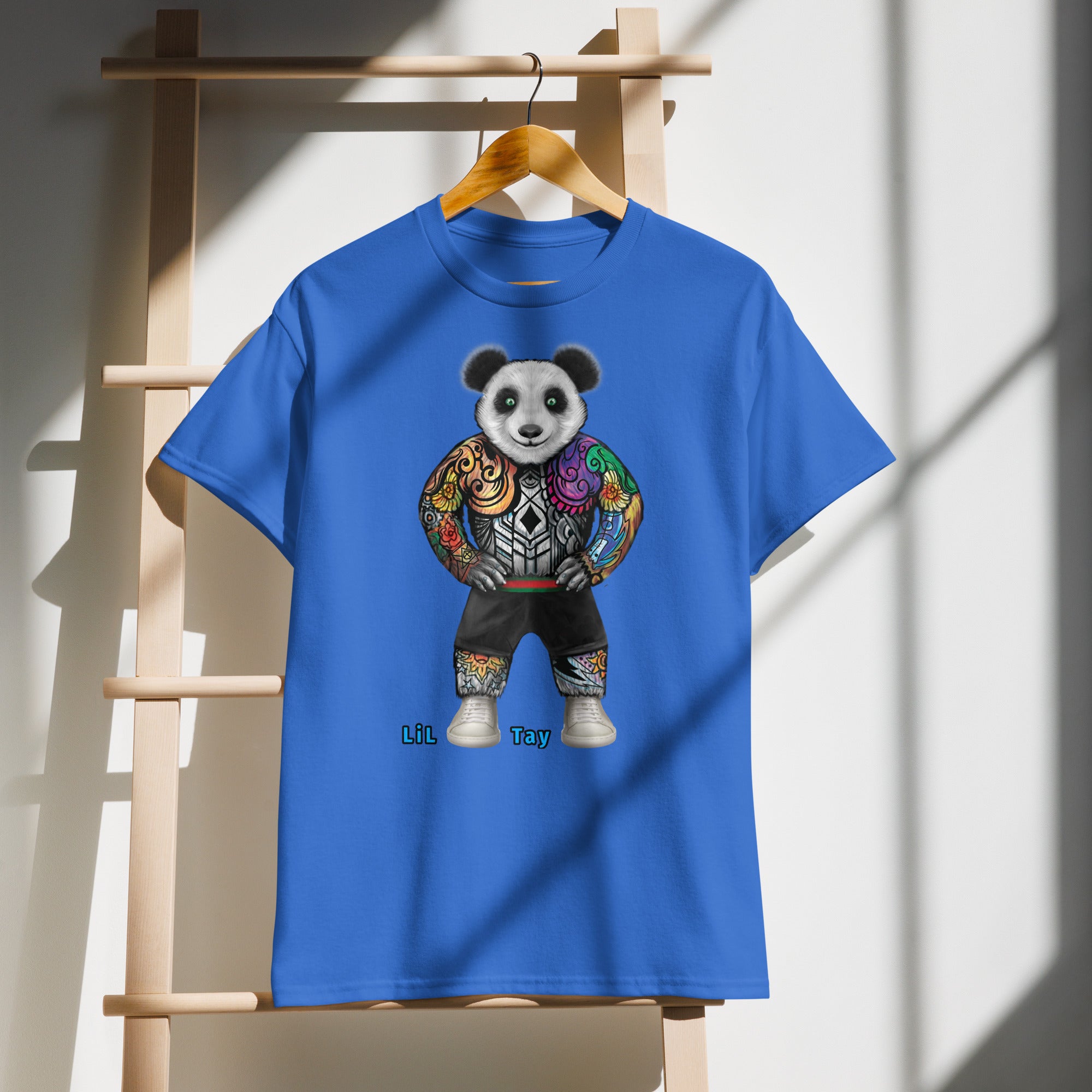 Blue t-shirt with a colorful panda design on a wooden hanger against a white wall.