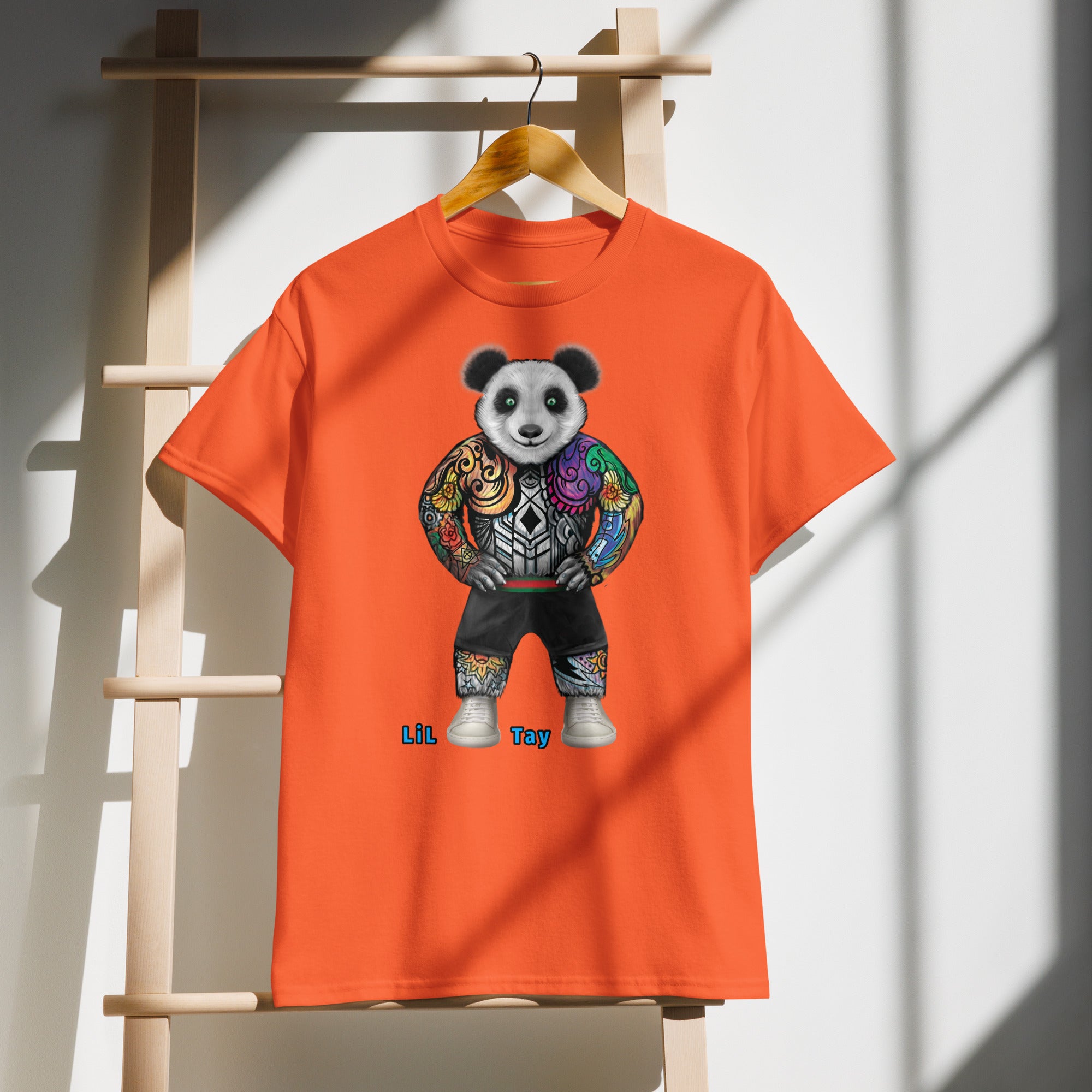 Orange t-shirt with a panda design on a wooden hanger against a white wall.